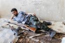 A Free Syrian Army fighter rests next to his weapons in al-Swaika district in Aleppo
