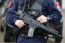 A policeman holds a HKG36 assault rifle as he secures the position in front of the city hall after two assailants had taken five people hostage in the church at Saint-Etienne-du -Rouvray near Rouen in Normandy