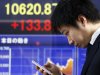 A man looks at his cellphone at an electronic stock board of a securities firm in Tokyo, Thursday, Jan. 24, 2013. Asian stock markets were mostly higher Thursday, supported by Congress averting a U.S. government default and a pickup in China's manufacturing in January.  (AP Photo/Koji Sasahara)