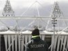 A security guard walks towards the Olympic Stadium in the London 2012 Olympic Park at Stratford in London