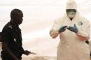 A Senegalese hygienist demonstrates how to protect oneself against the Ebola virus on April 8, 2014 at Dakar airport