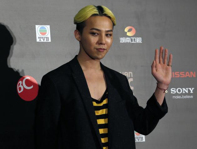 South Korean artist Kwon Ji-yong, stage name G-Dragon, waves to reporters backstage after winning four awards, including Best Male Artist, at the Mnet Asian Music Awards in Hong Kong