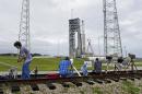 A United Launch Alliance Atlas V rocket stands ready for a second launch attempt at launch complex 41at the Cape Canaveral Air Force Station as photographers adjust their remote cameras, Friday, Dec. 4, 2015, in Cape Canaveral, Fla. The launch scheduled for early evening was scrubbed Thursday because of poor weather conditions. (AP Photo/John Raoux)