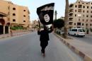 A member loyal to Islamic State waves a flag in Raqqa