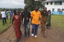 Four survivors of the Ebola outbreak walk at a clinic outside Monrovia