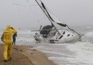 A stranded sailboat founders in the surf along the Willoughby Spit area of Norfolk, Va. as Hurricane Irene hits Norfolk, Va., Saturday, Aug. 27, 2011. The live-aboard couple attempted to outrun the storm and got caught up in the high surf and wind. They were rescued by local fire and rescue personnel. (AP Photo/Steve Helber)