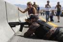 A protester aims his weapon from a bridge next to the Bureau of Land Management's base camp where seized cattle, that belonged to rancher Cliven Bundy, are being held at near Bunkerville