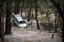 A car washed up against a tree in Cyprus Creek, a tributary of the Blanco River, in Wimberley