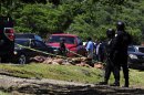 EDS NOTE GRAPHIC CONTENT - Mexican federal police secure the area where 17 dismembered bodies were found by a highway in the town of Tizapan el Alto near the border between Jalisco and Michoacan states, Mexico, Sept. 16, 2012. The Jalisco state prosecutor, Tomas Coronado Olmos, didn't reveal the identities of the slain but said the bodies were naked, mutilated and stacked with chains around their necks. (AP Photo/Bruno Gonzalez)