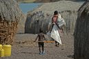 A mother and child walk in the village of Komote on the shores of Lake Turkana, northern Kenya on May 18, 2012