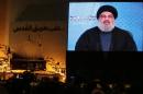 Shiite supporters watch Hassan Nasrallah, the head of Lebanon's militant Shiite Muslim movement Hezbollah, addressing them through a giant screen on January 30, 2014 in Beirut's southern suburb of Mujammaa Sayyed al-Shuhada