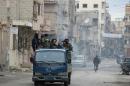 Rebels drive through the eastern Syrian town of Deir Ezzor on March 10, 2014