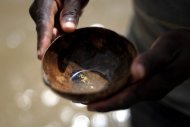 A gold prospector is seen showing grains of gold obtained along a river in South America. Guyana said on Friday it had suspended the granting of new permits to mine for gold and diamonds in rivers because of concerns over widespread pollution.