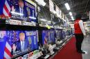 A salesclerk stands in front of flat-panel TVs showing Republican's front-runner candidate Donald Trump in a news program on the U.S. presidential election's Super Tuesday at an electronics store in Tokyo, Wednesday, March 2, 2016. After the Super Tuesday primaries and caucuses in a dozen states, Trump and Democrat candidate Hillary Clinton had tightened their grasp on their party's presidential nominations. (AP Photo/Shizuo Kambayashi)