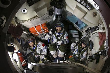 Chinese astronauts (from L to R) Zhang Xiaoguang, Nie Haisheng and Wang Yaping salute in a re-entry capsule during a training at Beijing Aerospace City in Beijing, April 29, 2013. REUTERS/Stringer
