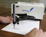 In this photo taken June 13, 2011, Damilic Corp. president Bob Olding anchors the paper as the Atlantic Plus, the Signascript tabletop model autopen, produces a signature at their Rockville, Md., office. Damilic Corp. is the leading manufacturer of automatic signing machines for replicating authentic signatures. Autopens have been used for decades by presidents of both parties, an open secret nobody in Washington wants to talk about, including the White House. (AP Photo/Manuel Balce Ceneta)