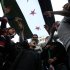 Anti-Syrian regime protesters stand beneath a Syrian revolution flag and chant slogans against Syrian President Bashar Assad during a demonstration after Friday prayers in Beirut, Friday, March 23, 2012. (AP Photo/Bilal Hussein)