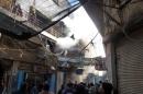 Iraqis look up as smoke billows from a building that was hit in an explosion in central Baghdad on February 5, 2014