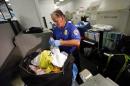 Transportation Security Administration baggage screener checks passengers' luggage at Miami International Airport in Miami