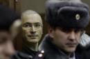 FILE In this Thursday, Dec. 30, 2010 file photo Mikhail Khodorkovsky, left, looks from behind glass at a court room in Moscow, Russia. Russian President Vladimir Putin said on Thursday Dec. 19, 2013, that he will pardon his arch-enemy Khodorkovsky who has spent the past 10 years in prison on tax evasion and embezzlement charges. Khodorkovsky's release could potentially be Putin's biggest political decision this year. (AP Photo/Ivan Sekretarev, File)