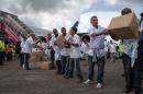 Members of a team of 165 Cuban doctors and health workers unload boxes of medical material upon their arrival in Sierra Leone to help fight Ebola on October 2, 2014