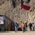 In this May 23, 2013 photo, security officers walk away from the entrance of the Barrick Gold Corp's Pascua-Lama facilities, in northern Chile. Chile's environmental regulator blocked Barrick Gold Corp.'s $8.5 billion Pascua-Lama project on Friday, May 24, 2013, and imposed its maximum fine on the world's largest gold miner, citing "very serious" violations of its environmental permit as well as a failure by the company to accurately describe what it had done wrong. (AP Photo/Jorge Saenz)