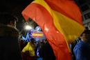 A Popular Party supporter holds a Spanish flag in front of the party's headquarters in Madrid on December 20, 2015