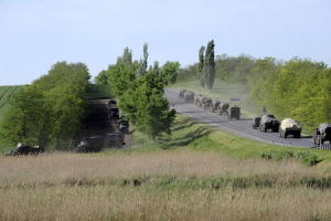 Military vehicles drive along road at Russian southern &hellip;