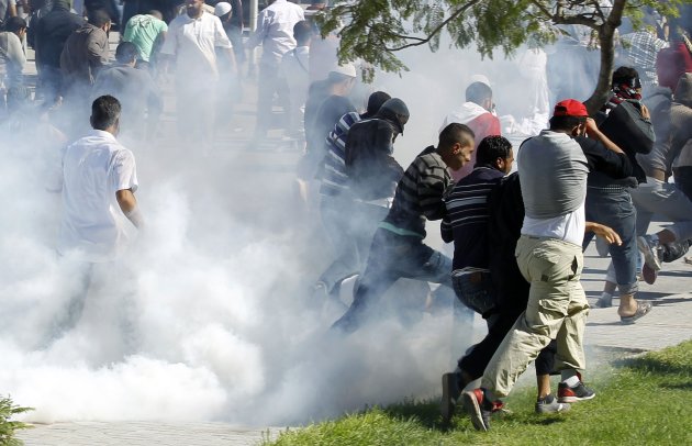 Protesters run for cover during a demonstration in front of the U.S. Embassy in Tunis September 14, 2012. At least five protesters were wounded when Tunisian police opened fire on Friday to quell an assault on the U.S. embassy compound in the capital Tunis, a Reuters reporter said. It was not immediately clear if police fired live rounds or rubber bullets. A large fire erupted inside the compound which has been invaded by hundreds of people incensed by a U.S.-made film that demeans the Prophet Mohammad. REUTERS/Zoubeir Souissi  (TUNISIA - Tags: POLITICS CIVIL UNREST RELIGION)