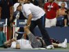 A trainer works on Mardy Fish during his match against Jo-Wilfried Tsonga of France during the U.S. Open tennis tournament in New York, Monday, Sept. 5, 2011. (AP Photo/Mel Evans)