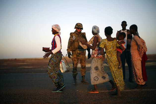 FILE- In file photo taken on Thursday, Feb.14, 2013, a French soldier checks female passengers of a transport truck arriving in Gao, northern Mali. Youth in the recently-liberated Malian city of Gao held a sit-in in the center of the city on Thursday, May 30, 2013, to protest against what they see as France's tacit support of the Tuareg ethnic group, the first indication that the mood toward the French in Mali is changing. Gao was the first city where Islamic extremists were pushed out by French forces in January, and is now where the population is staging the first act of protest against the French. (AP Photo/Jerome Delay, File)