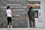 La zona euro alcanzó un acuerdo el sábado para conceder a Chipre un rescate valorado en 10.000 millones de euros (13.000 millones de dólares) pero exigió a los depositantes de sus bancos que renuncien a parte de su dinero para evitar la quiebra, a pesar del riesgo de una fuga de fondos de las entidades financieras. En la imagen, gente ante un cajero automático en Nicosia, el 16 de marzo de 2013. REUTERS/Yiannis Nisiotis