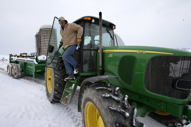 In this Saturday, Jan. 26, 2013 photo, Shawn Georgetti climbs out of his John Deere tractor on his 167-acre family dairy farm in Avella, Pa. With royalties from a Range Resources gas well on his property, Georgetti has been able to buy newer farm equipment that's bigger, faster, and more fuel-efficient. (AP Photo/Gene J. Puskar)