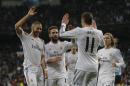 Real Madrid's Karim Benzema from France, left, celebrates his goal with Real Madrid's Gareth Bale from Great Britain, second right, and teammates during a Spanish La Liga soccer match between Real Madrid and Villarreal at the Bernabeu stadium stadium in Madrid, Spain, Saturday, Feb. 8, 2014. (AP Photo/Andres Kudacki)