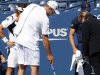 Andy Roddick of USA points to a wet spot on the court to an official as opponent David Ferrer of Spain, far left, looks on prior to their match on Louis Armstrong Stadium in the fourth round at the U.S. Open tennis tournament in New York, Thursday, Sept. 8, 2011. The court was deemed unplayable due to water coming up through the playing surface after two days of steady rain and delays.(AP Photo/Charles Krupa)