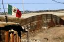A Mexican flag flies next to the wall which separates Mexico from the United States in Tijuana
