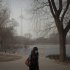 A woman wears a mask while walking in a park near the China Central Television Tower, background, on a hazy day in Beijing, China, Monday, Jan. 14, 2013. Beijing schools kept children indoors and hospitals saw a spike in respiratory cases Monday following a weekend of off-the charts pollution in China's smoggy capital, the worst since the government began being more open about air-quality data. (AP Photo/Alexander F. Yuan)