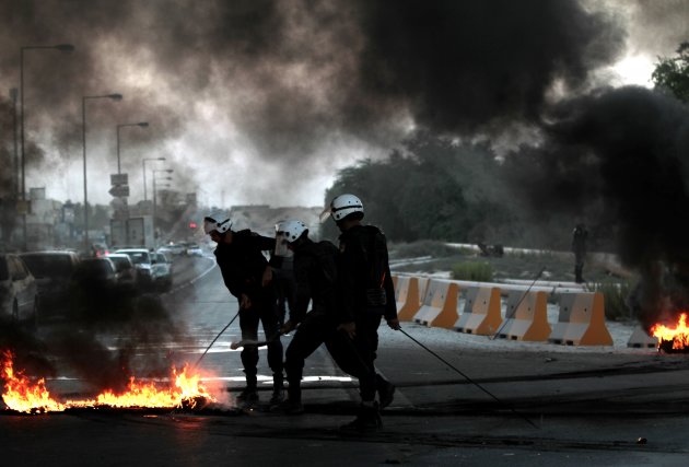 Riot police extinguish burning …