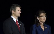 Sarah Palin (R) and her husband Todd (L) are seen in a rally at the Arizona Biltmore Resort & Spa 2008. Sarah Palin's husband jumped to her defense Thursday after an upcoming book claimed the Republican politician snorted cocaine off an oil drum and had a premarital fling with an African-American basketball star