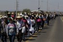 Pilgrims walk along a road toward the site where Pope Benedict XVI will give a Sunday Mass in Bicentennial Park near Silao, Mexico, Saturday March 24, 2012. Benedict arrived in Mexico Friday afternoon, a decade after the late Pope John Paul II's last visit. The pontiff's weeklong trip to Mexico and then to Cuba on Monday is his first to both countries. (AP Photo/Dario Lopez-Mills)