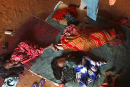 In this photograph taken Sunday Aug. 7, 2011, A Somali refugee whose identity is being withheld to protect her as a rape victim, lays in her hut with her children at the Ifo refugee camp outside Dadaab, Eastern Kenya, 100 kms (60 miles) from the Somali border. speaking to AP, she said she was gang-raped by five men after a group of families traveling together were ambushed. Sexual attacks against famine refugees from Somalis fleeing to Kenya are rising dramatically, but Kenyan police say they don't have enough manpower to stop the attacks. That lack of manpower underscores a larger problem for Kenya: Officials here say they are being overwhelmed by the influx of tens of thousands of Somali refugees, and they're letting U.S., U.N. and other world leaders know about it. (AP Photo/Jerome Delay)
