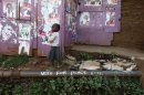 A young girl walks past election posters and a slogan calling for peace in the Kibera slum in Nairobi