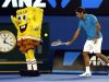 Federer of Switzerland hits a ball into the back of a man dressed as the cartoon character Sponge Bob Square Pants during Kids Tennis Day in Melbourne
