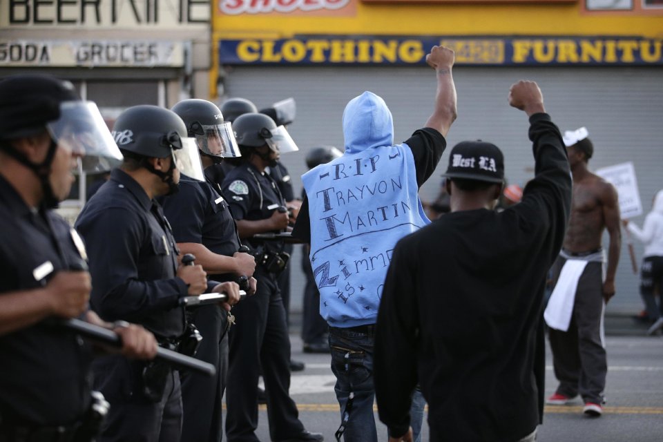 Protesters confront Los Angles police officers during a demonstration in reaction to the acquittal of neighborhood watch volunteer George Zimmerman on Monday, July 15, 2013, in Los Angeles. Anger over the acquittal of a U.S. neighborhood watch volunteer who shot dead an unarmed black teenager continued Monday, with civil rights leaders saying mostly peaceful protests will continue this weekend with vigils in dozens of cities. (AP Photo/Jae C. Hong)