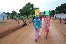 Women carry buckets of water in the streets of the Muslim area in Boda, southern Central African Republic on May 21, 2015