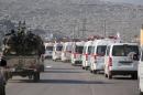 A convoy of ambulances transporting wounded civilians and rebels from the villages of Fuaa and Kafraya, the last two regime-held villages in Idlib province, is guarded as it heads towards the Cilvegozu crossing with Turkey on December 28, 2015
