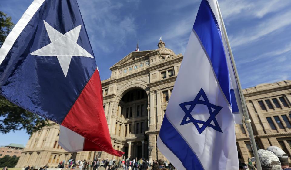 The Texas and Israeli flags are waved by protesters who gathered to disrupt and heckle a group gathered for a Texas Muslim Capitol Day rally, Thursday...
