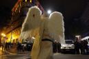 Demonstrator dressed as an angel faces French riot police officers during a rally in Marseille