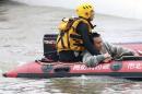 A survivor is rescued from a commercial plane, after it crashed in Taipei, Taiwan, Wednesday, Feb. 4, 2015. The Taiwanese commercial flight with 58 people aboard clipped a bridge shortly after takeoff and crashed into a river in the island's capital on Wednesday morning. (AP Photo) TAIWAN OUT