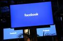A Facebook logo is pictured on a screen ahead of a press conference to announce the launch of it's latest product "Workplace", in central London on October 10, 2016